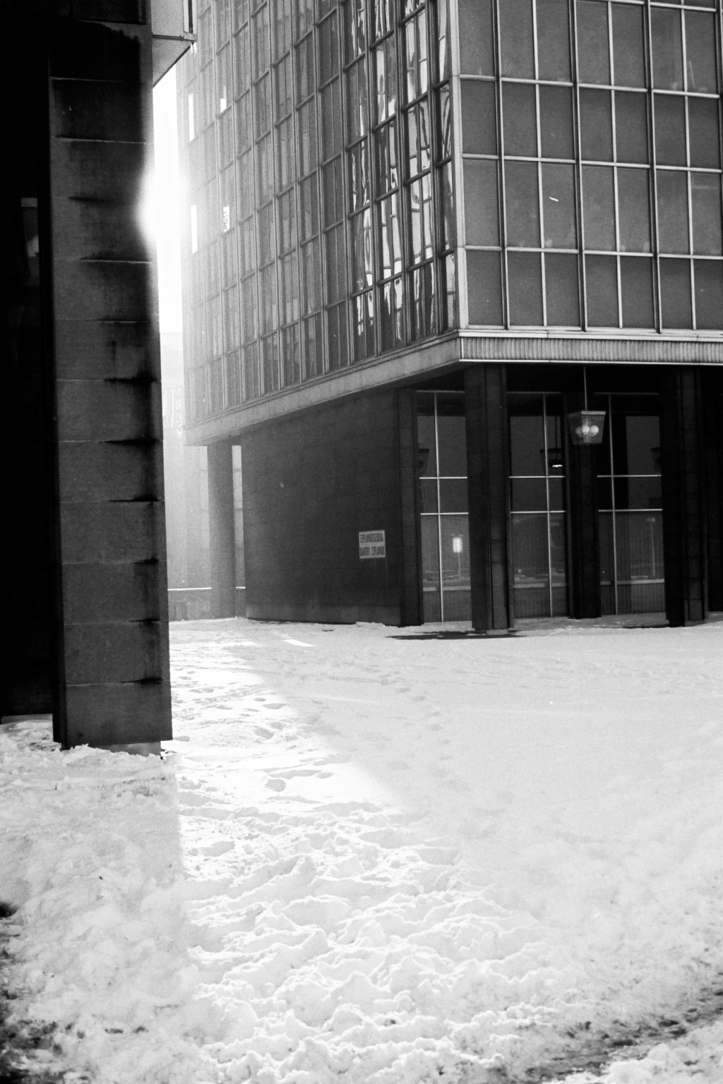 Dans un quartier d&rsquo;affaires désert à Bruxelles, traces de pas dans la neige, signes fragiles de présences&nbsp;humaines.