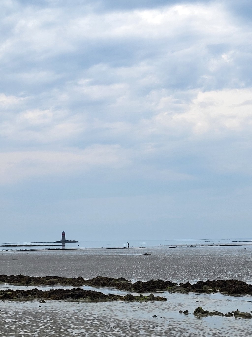 Sur la plage de Granville, paysage minimal où ciel, sable et eau se confondent dans un horizon&nbsp;indistinct.