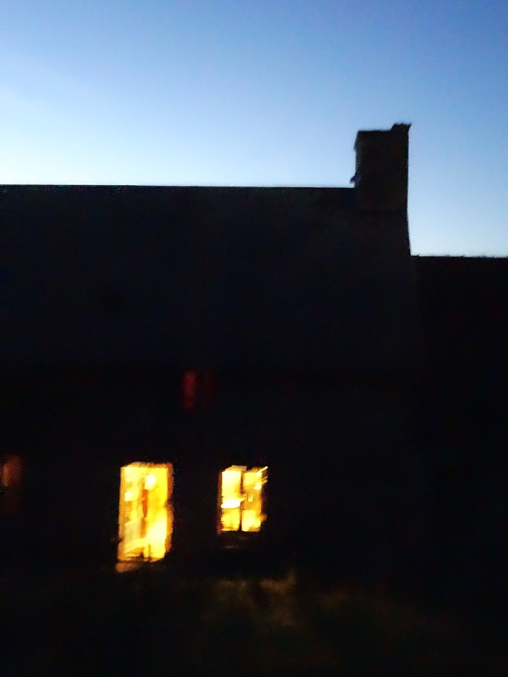 Vue sur la maison faiblement éclairée à la tombée de la&nbsp;nuit.