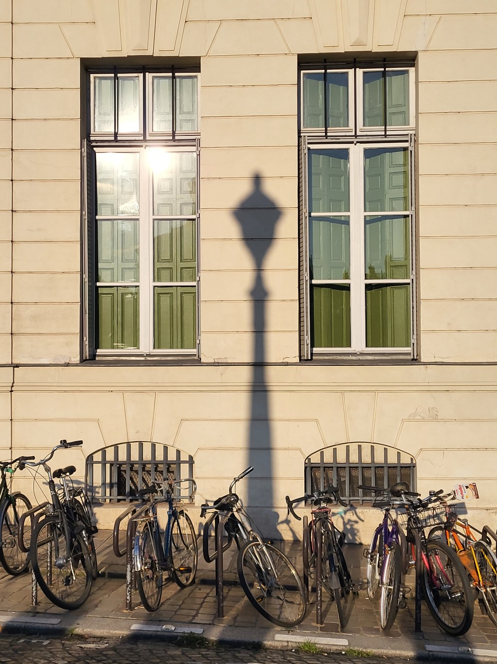 En longeant le Quai de Corse, l&rsquo;ombre portée d&rsquo;un réverbère sur une façade en pierre de&nbsp;taille.
