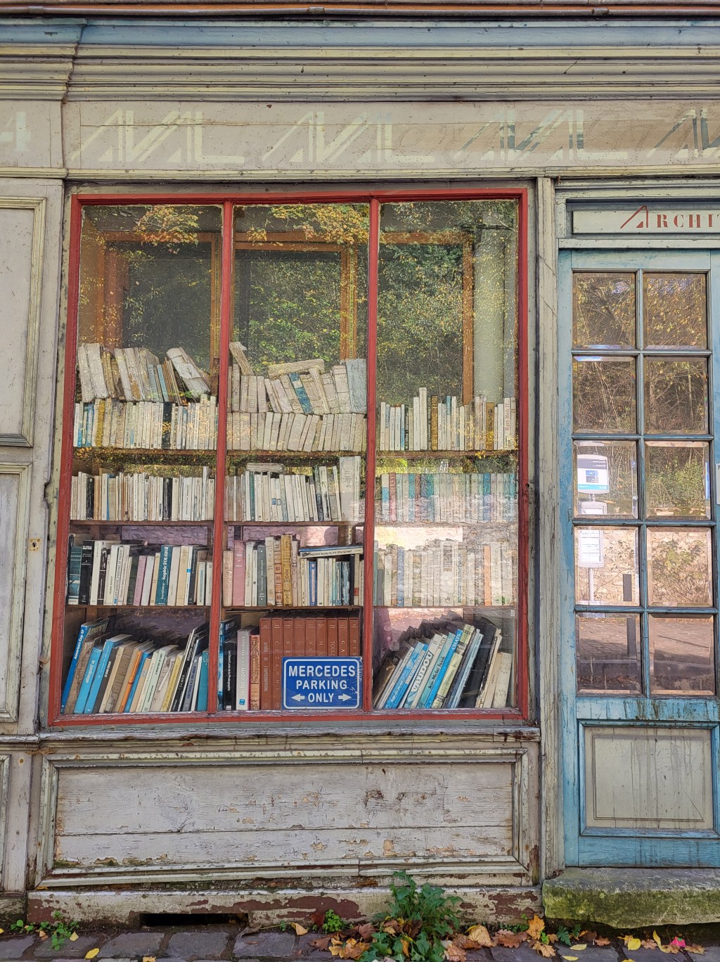 En chemin vers la maison de Chateaubriand, une vitrine de livres en vrac au rez-de-chaussée d&rsquo;une maison à l&rsquo;abandon.